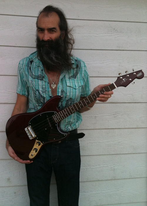 Warren Ellis with his signature Eastwood Tenor Guitar (Cherry Finish)